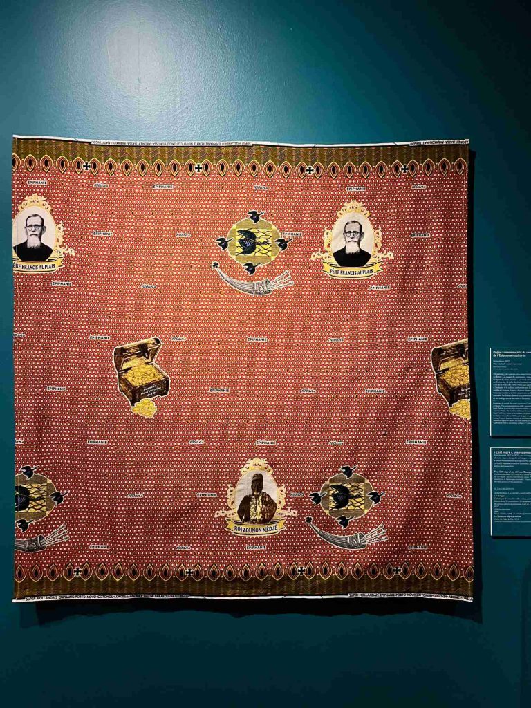 A portrait of Père Francis Aupiais printed on traditional West African wax fabric, a commemorative textile celebrating the historical mission to Dahomey.