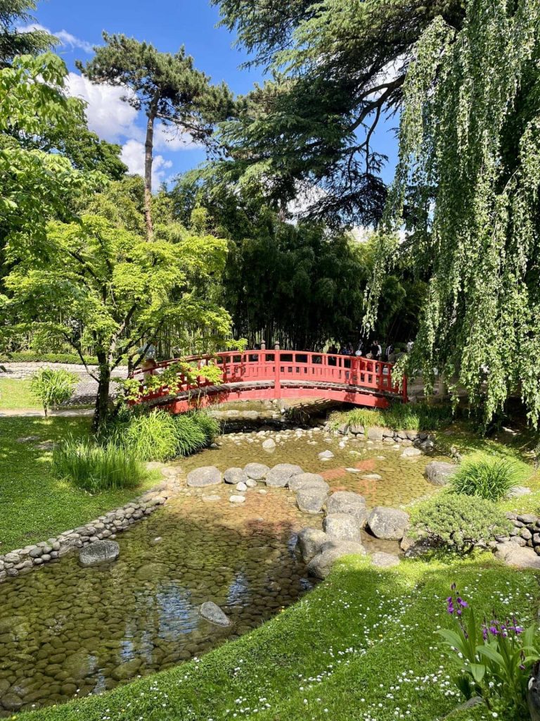 The iconic red bridge at Musée Albert-Kahn,surrounded by lush greenery in the Japanese Garden. The perfect Instagrammable picture spot. 